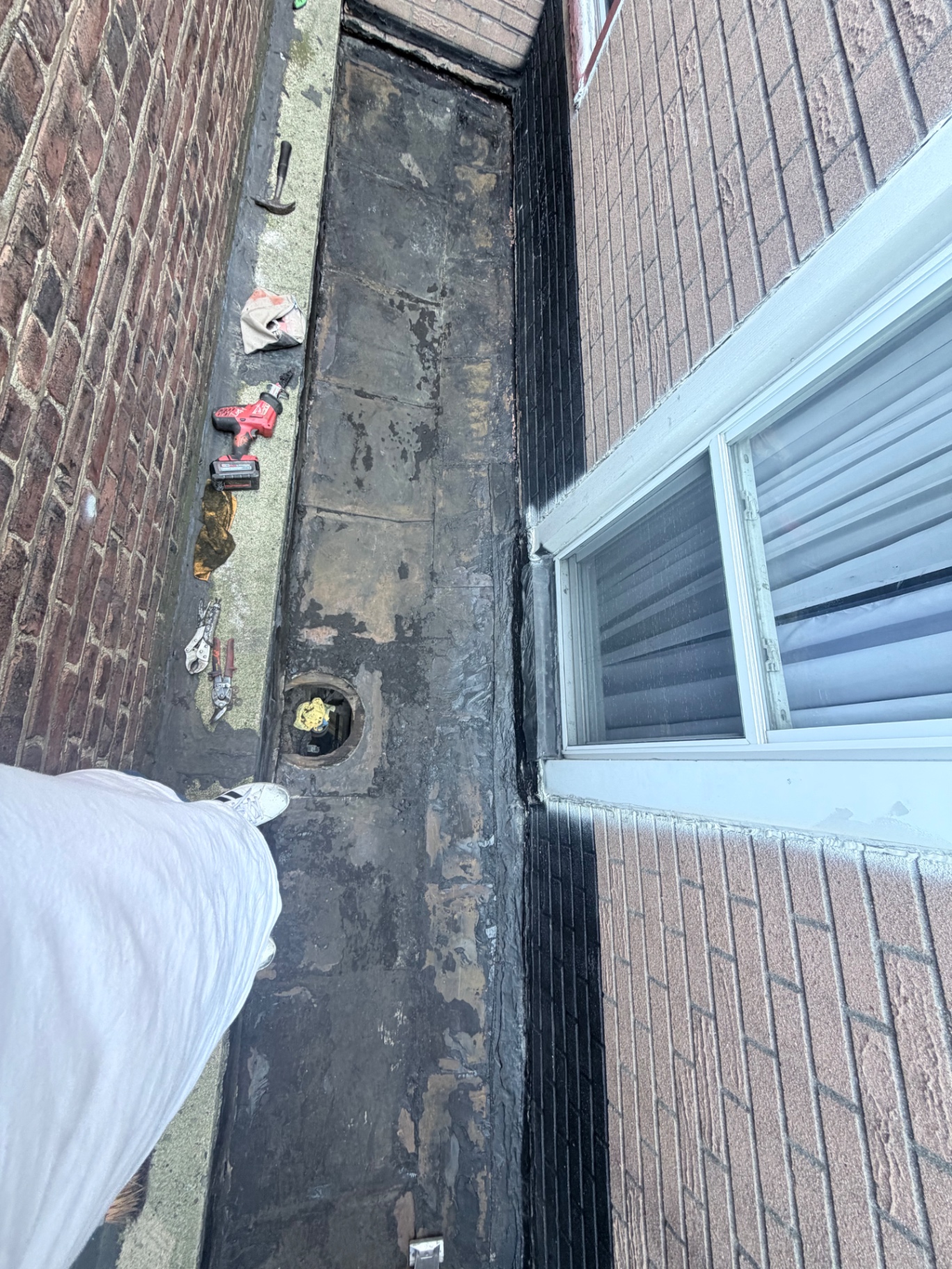 Existing flat roof surface around the drain before repair