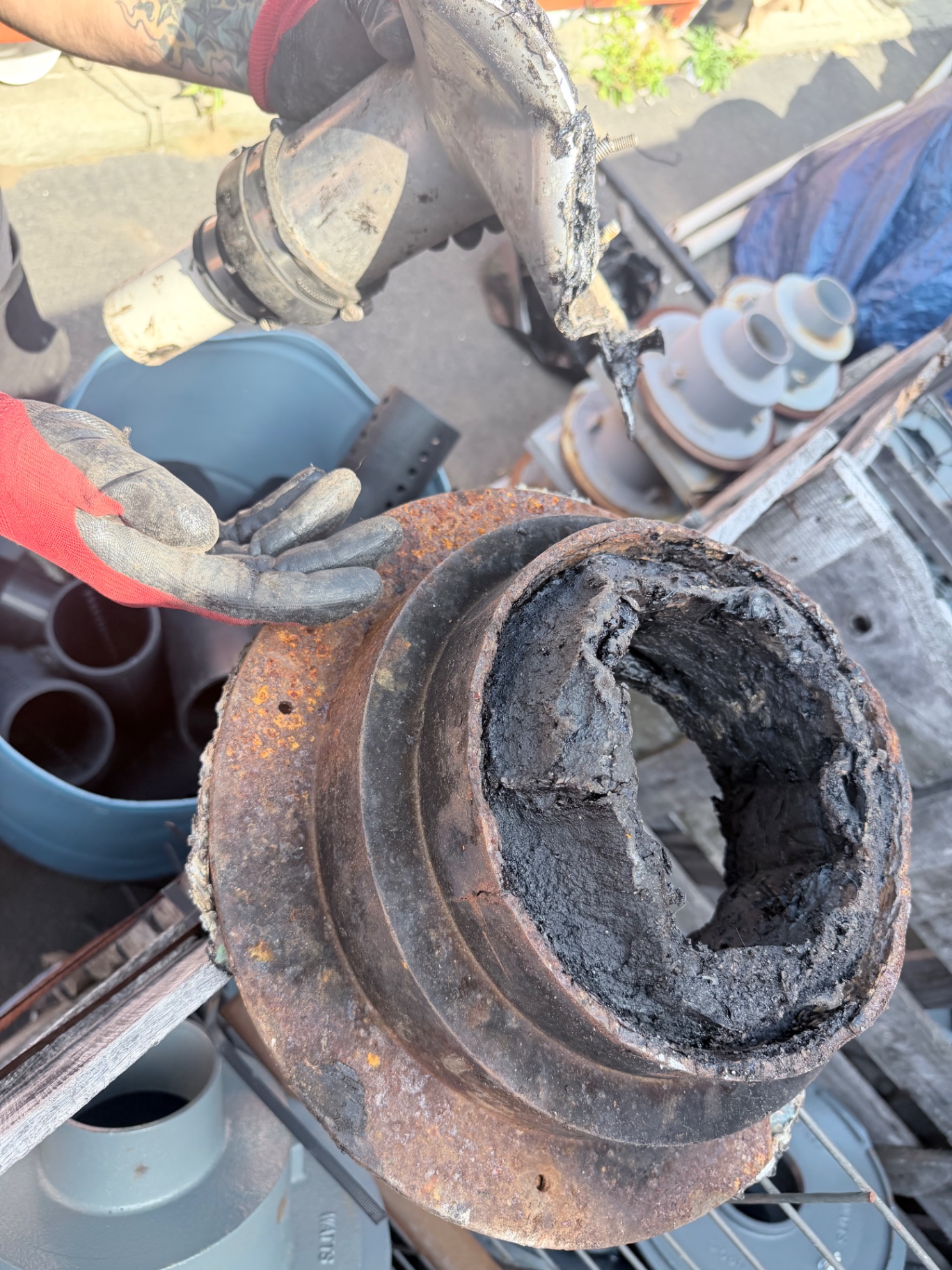Removed roof drain fitting showing built-up material